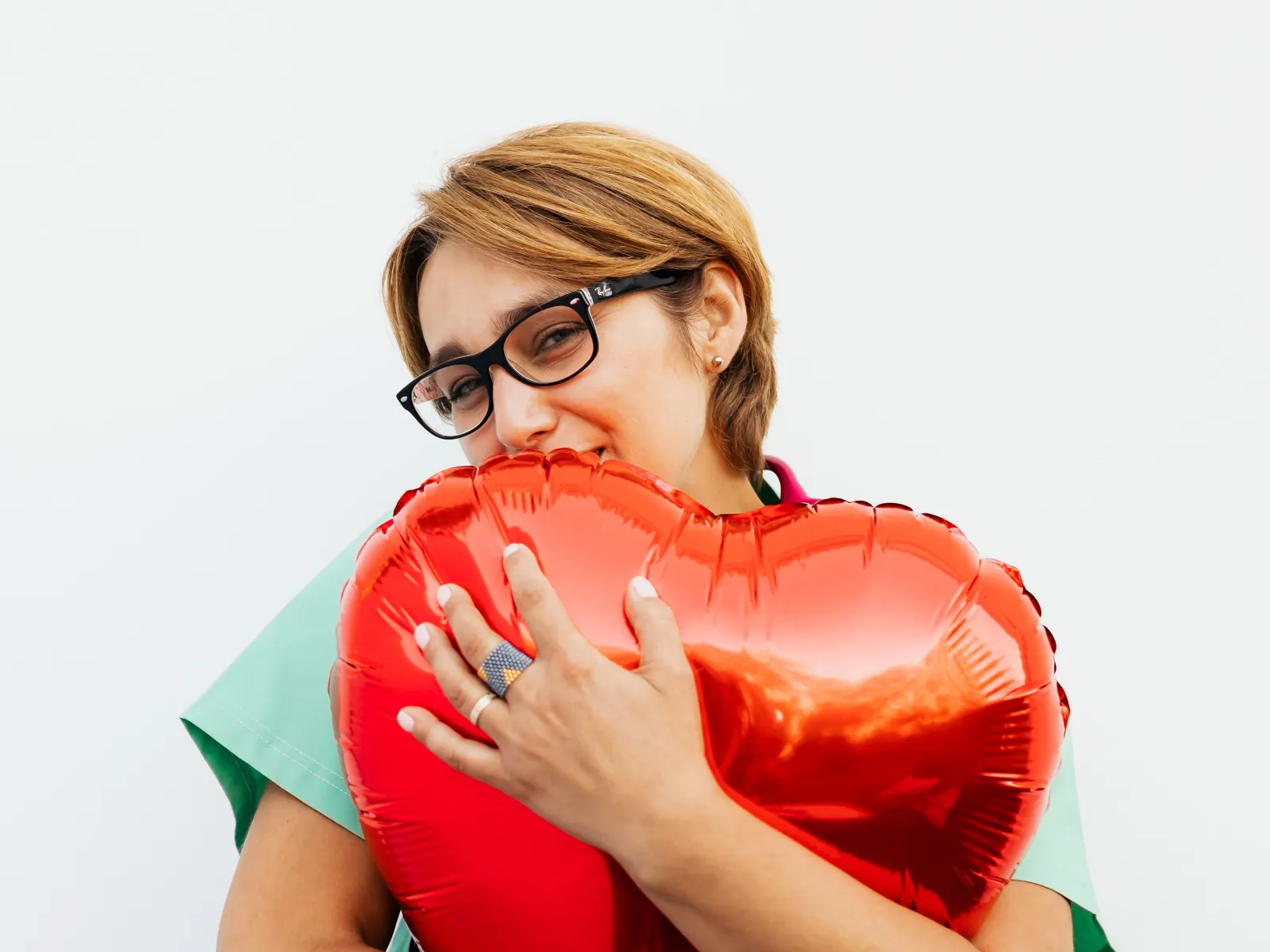 Profesional abrazando con cariño un globo con forma de corazón rojo