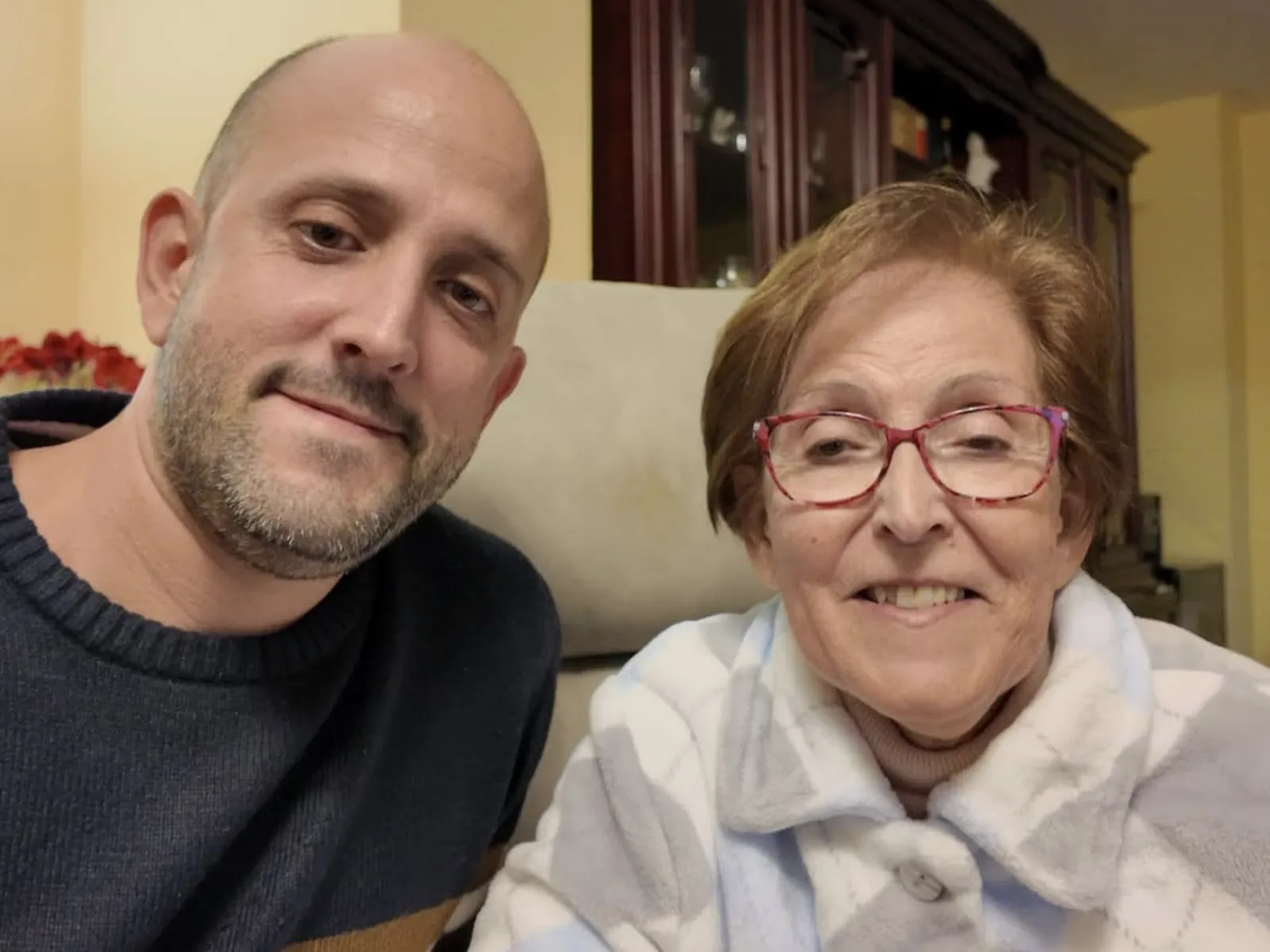 Víctor junto a su madre, Claudette, sonriendo los dos en el salón de casa